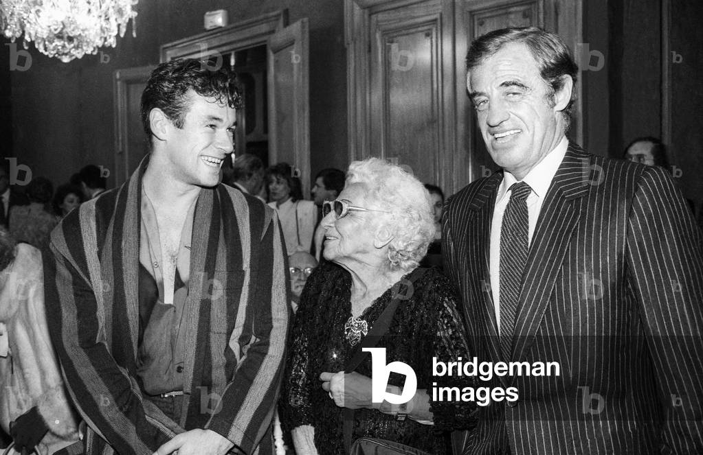 French dancer Patrick Dupond congratulated by French actor Jean Paul Belmondo and his mother Sarah Rainaud Richard Belmondo on his PaulBelmondo award on October 28, 1986 (b/w photo)