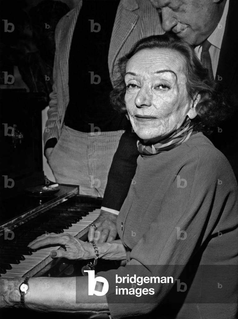 French Actress Mireille Balin At L'Association La Roule Turns In Front Of The Piano She Just Receive Thanks to Comedian Jacques Maurice March 31, 1967. (b/w photo)