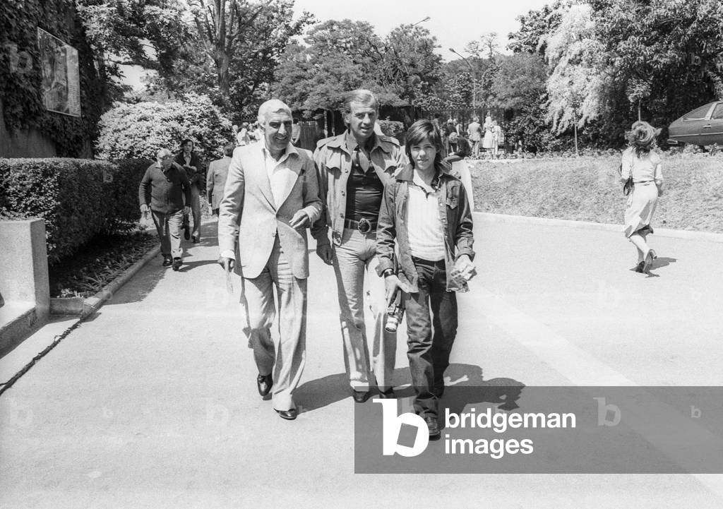 French actors Charles Gerard and Jean Paul Belmondo with his son Paul going to Roland Garros tennis tournament on May 31, 1977 (b/w photo)