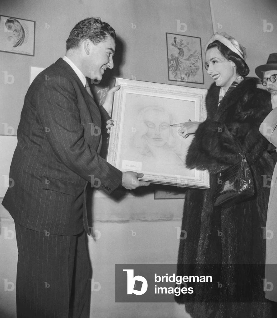 Art exhibition (works of art made by actors), at the Palais des Beaux Arts in Paris, December 16, 1950 : French actress Marcelle Derrien showing her canvas to the director of the exhibition (b/w photo)