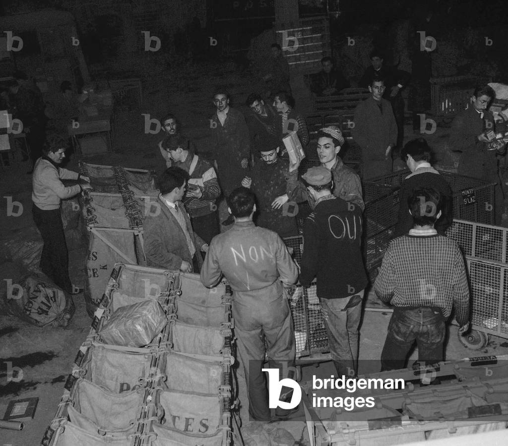 French referendum on Algerian self-determination (January 8, 1961) : in a sorting office, 2 employees displaying their opinion, Paris, December 28, 1960 (b/w photo)