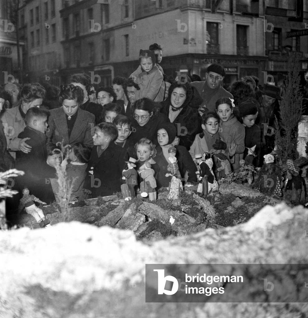Children and Their Parents Looking at A Crib in The Street, at Time of Christmas, Paris, December 1948 (b/w photo)