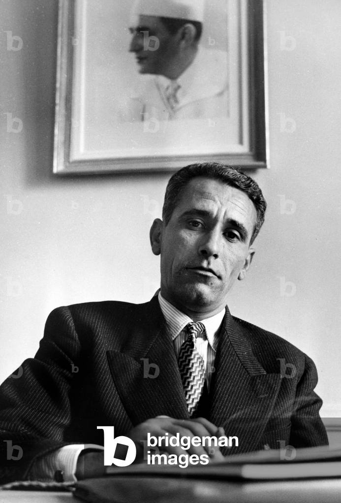 Mr Bouabid Ambassador of Morocco to France, here at his office of the Embassy of Morocco in Paris In front of a Portrait of the Sultan of Morocco 21 June 1956 (b/w photo)