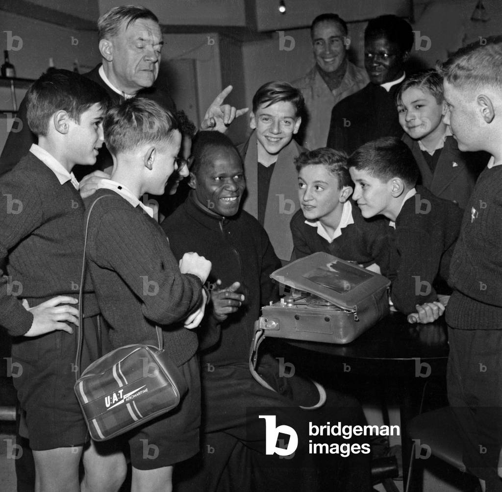 In Le Hall De L'Aerogare Du Bourget The Little Singers Of The Wood Cross Listen To A Song He Just Recording Under Bishop Maillet's Direction On December 9, 1961 (b/w photo)