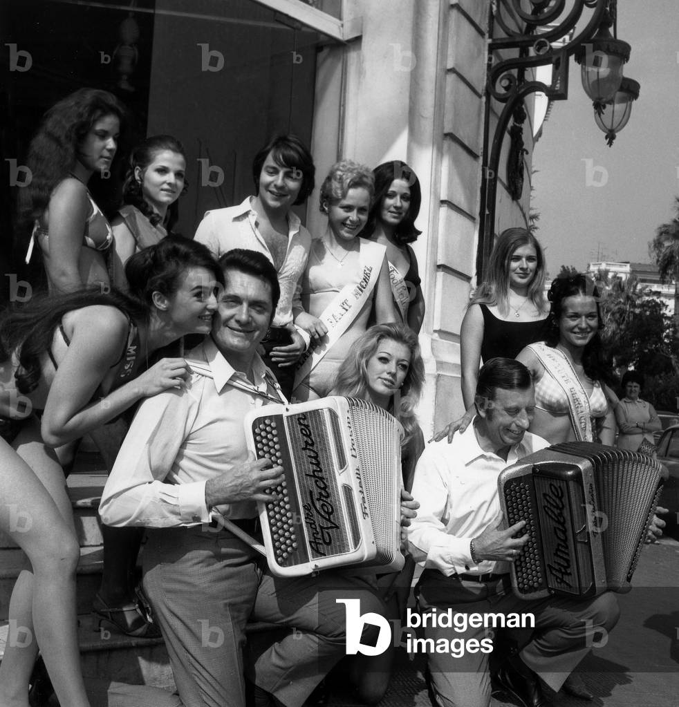 Surrounding Accordeonists Andre Verchuren (Left) And Aimable And Singer Monti (In the background) These Pretty Girls Are Candidates For Queen Of The Cote D Azur At Casino Royale De Nice October 4, 1969 (b/w photo)