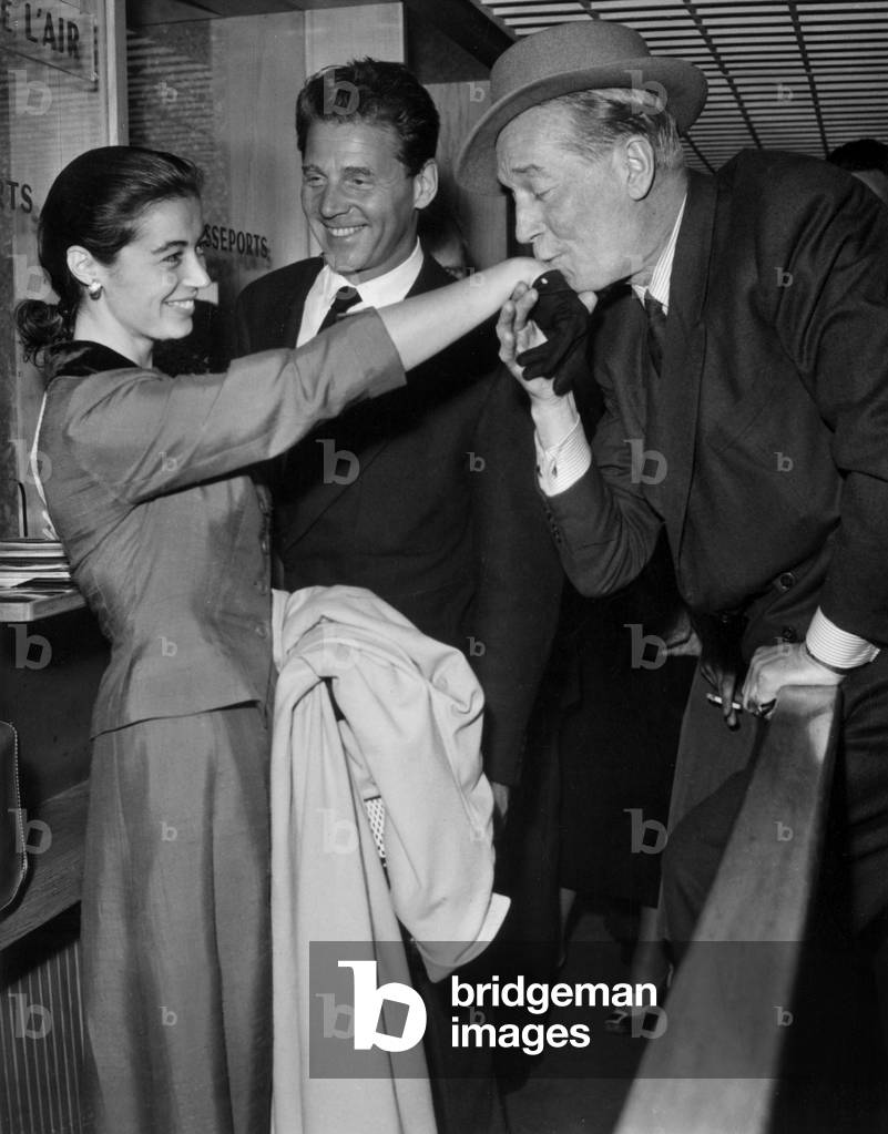 At The Arrival at The Airport in Paris The Actor Maurice Chevalier Kiss The Hand of The Wife of The Actor Jean Pierre Aumont, May 23, 1956 (b/w photo)