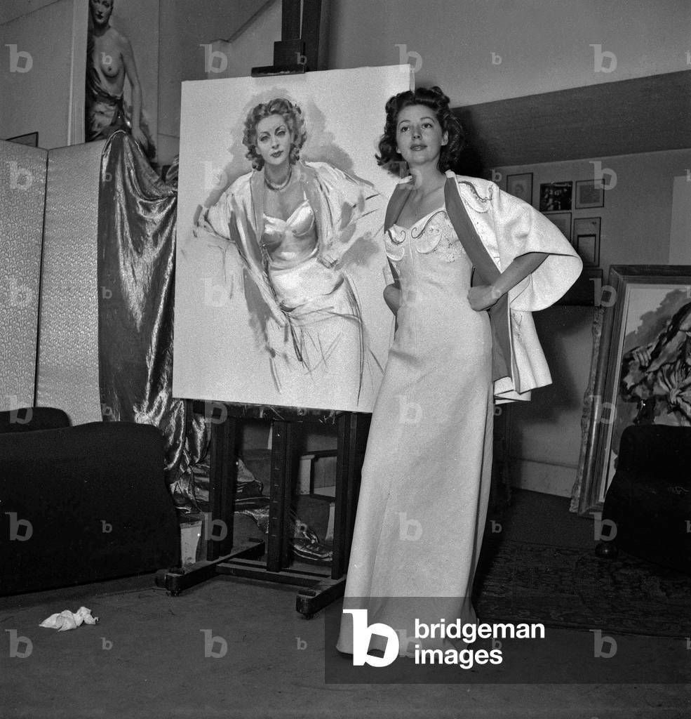 French actress Anne Vernon and her portrait by painter Jean-Dominique Van Caulaert, Paris, July 26, 1949 (b/w photo)