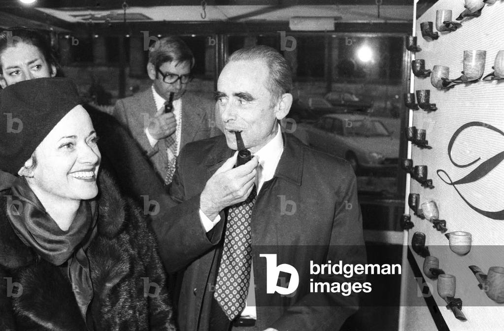 French director Henri Georges Clouzot testing a new pipe, Paris, March 11, 1976 (b/w photo)
