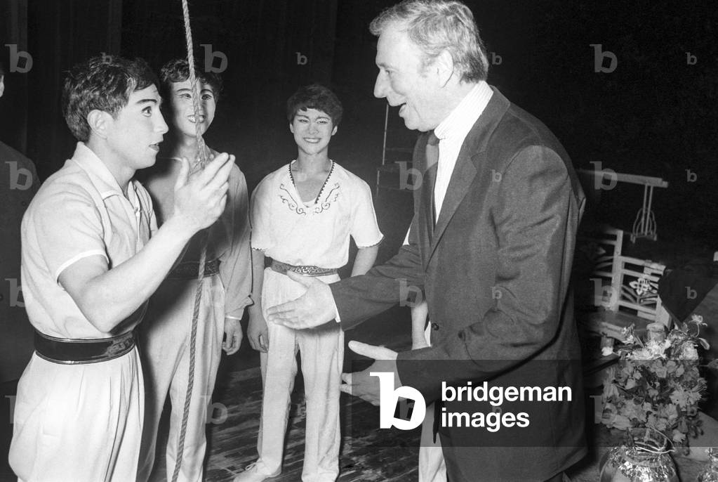 Yves Montand attending a performance of the Peking Circus in Paris on May 18, 1981, here speaking with the artists (b/w photo)