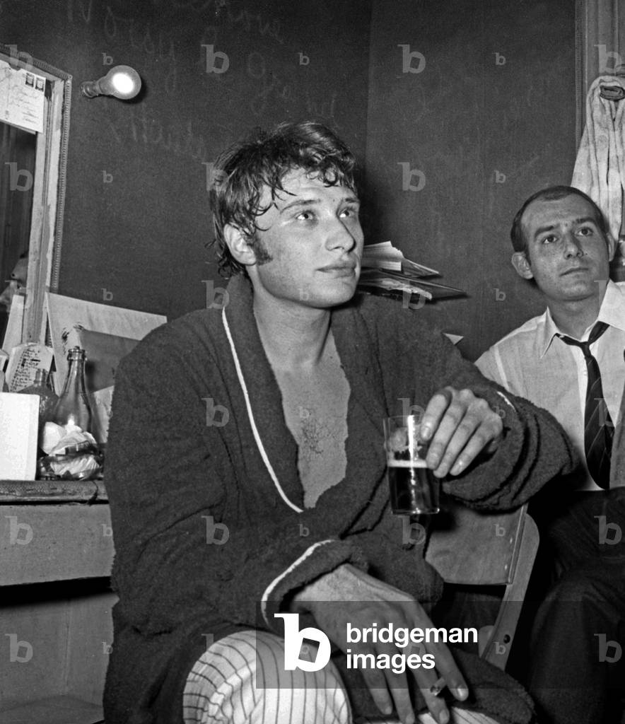 Johnny Hallyday after his concert at the Olympia in his dressing room, smoking a cigarette, 19 October 1966 (photo)