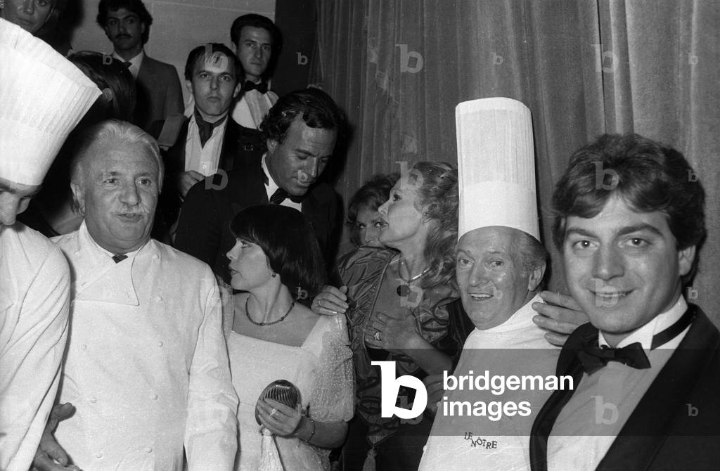 Birthday (40 years old) of Julio Iglesias, Pre Catelan, Paris, February 27, 1983 : Julio Iglesias (c), on l the cook Roger Verge and on r the pastry cook Gaston Lenotre (b/w photo)
