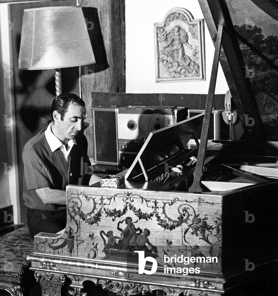 Charles Aznavour playing the piano, 1965 (photo)