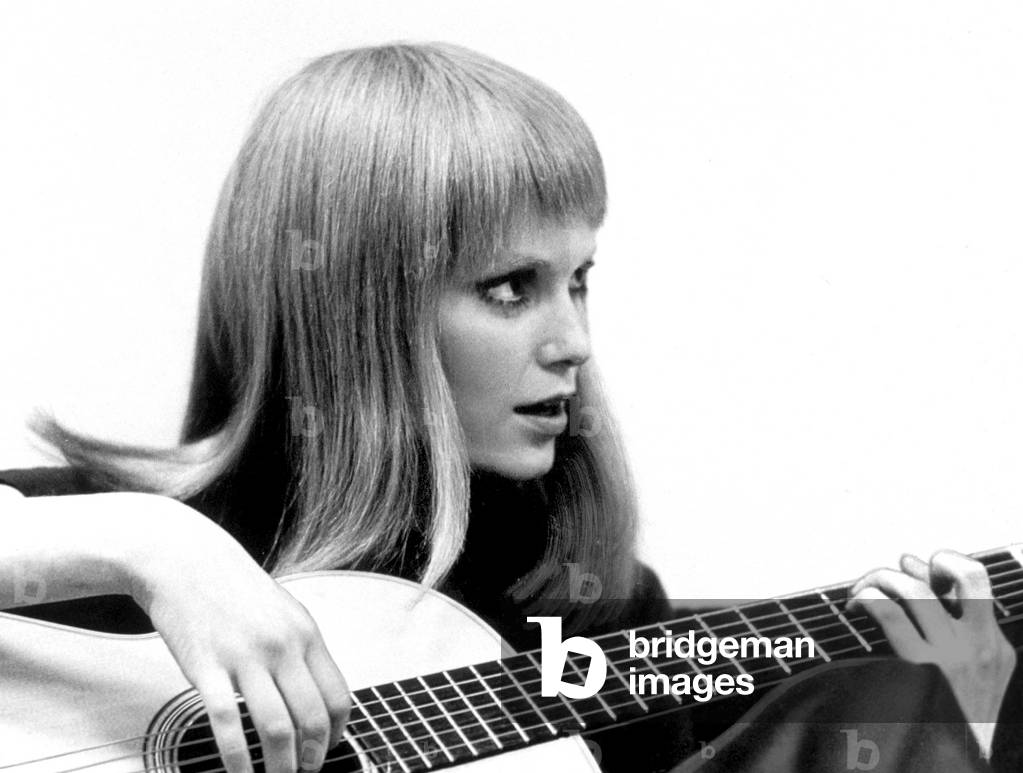 Mia Farrow playing guitar in 1969 (photo)