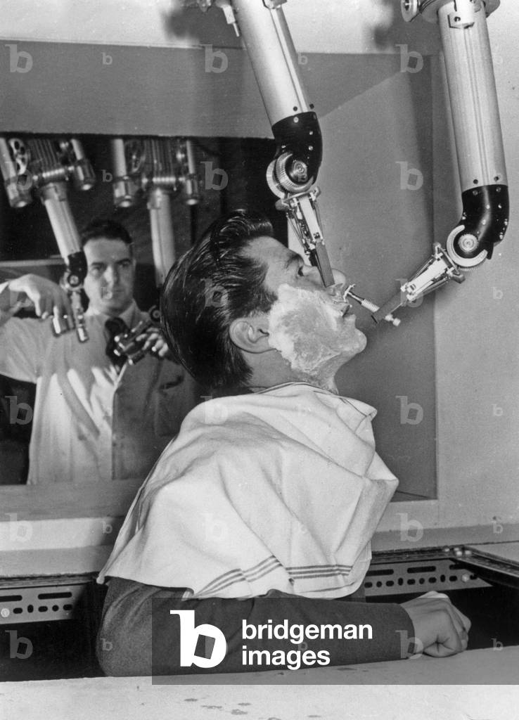 The “Mecanic Hand” Shaving A Man Has Perfection With A Simple Mecanic Shaver In His Clamp The Nose On March 1, 1957 (b/w photo)