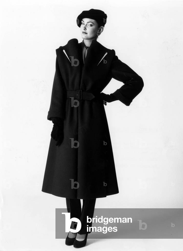 Overcoat in cashmere belt in dark blue casmire, lapels of rhinestone arrows. Tone-on-tone sheet trousers, velvet beret, Walter Steiger suede pumps for Nina Ricci. Collection Nina Ricci Autumne/Winter 1979-80. Neg: B12461PL