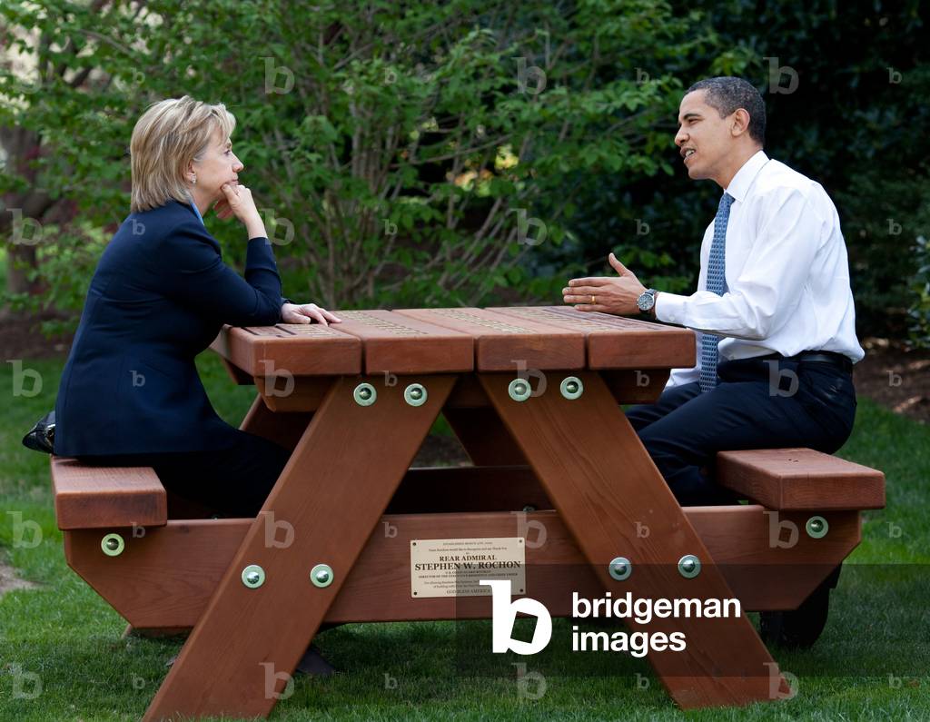 President Barack Obama and Secretary of State Hillary Rodham Clinton speak together sitting at a picnic table April 9, 2009, on the South Lawn of the White House