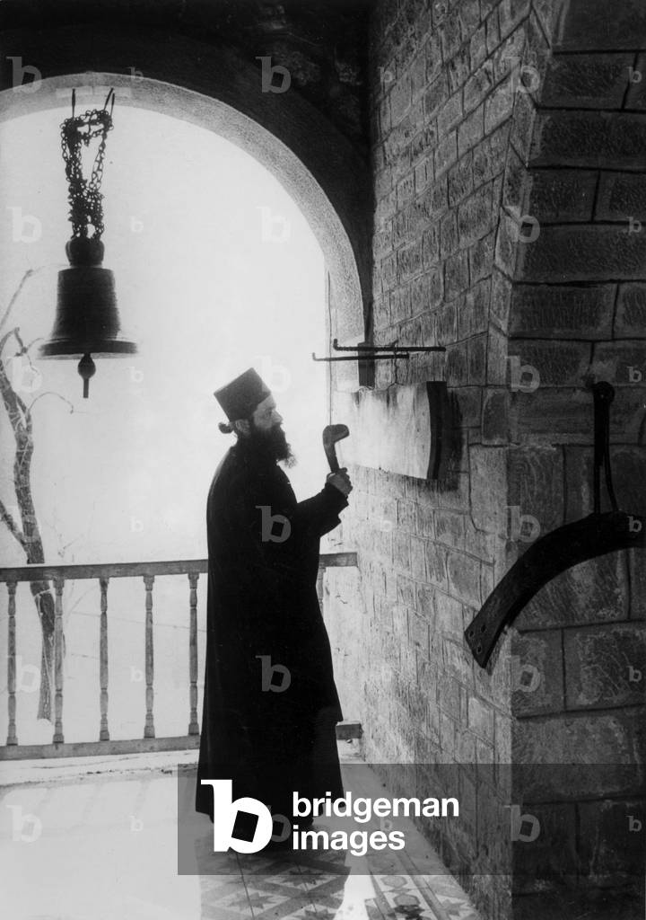 At the monastery of Varlaam on the mount Athos in Greece, the Father Arsenio ringing the gong, c. 1955