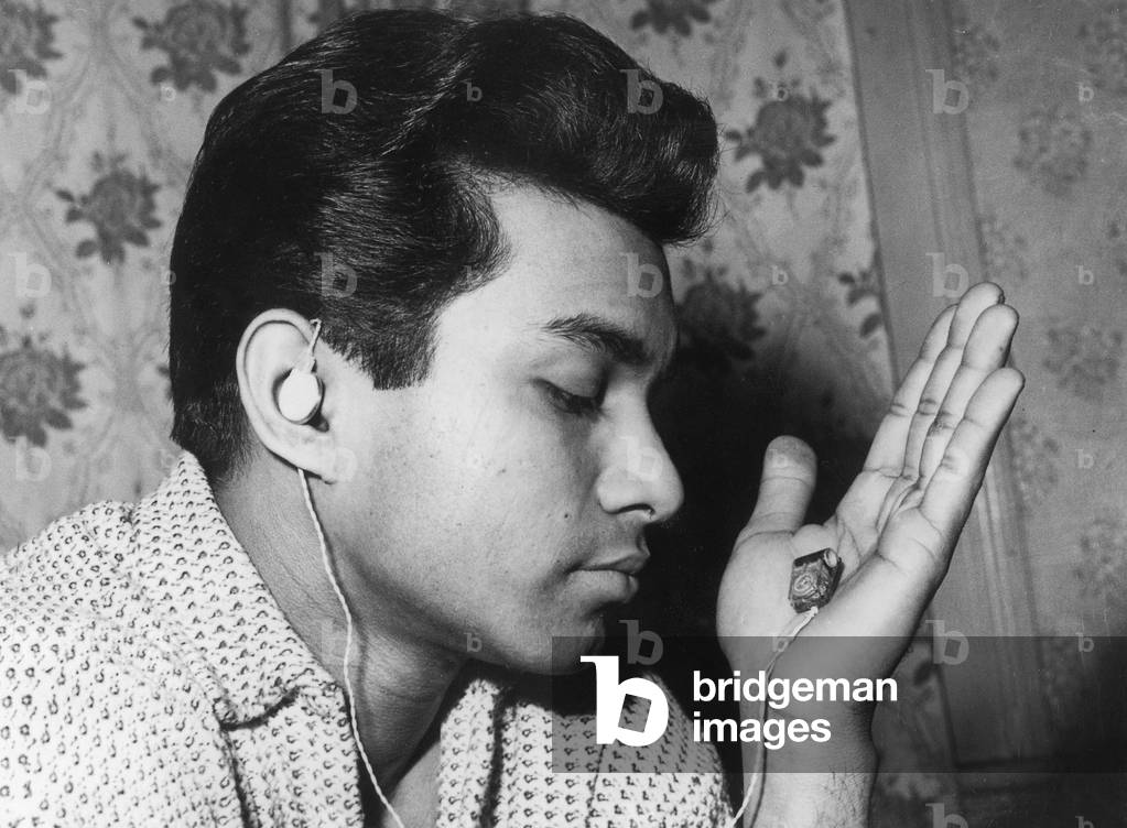 young Randoplh Sookhoo listening to the miniature radio receiver he made himself February 13, 1960