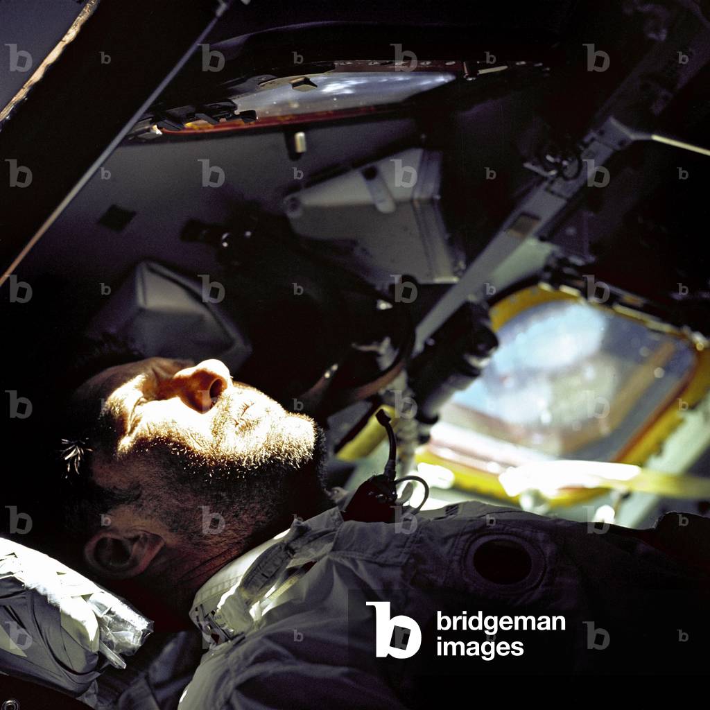 A heavy beard covers the face of Astronaut Walter M. Schirra, Jr., Apollo 7 Commander, as he looks out the rendez vous window in front of the Commander's station on the ninth day of the Apollo 7 Earth orbital mission