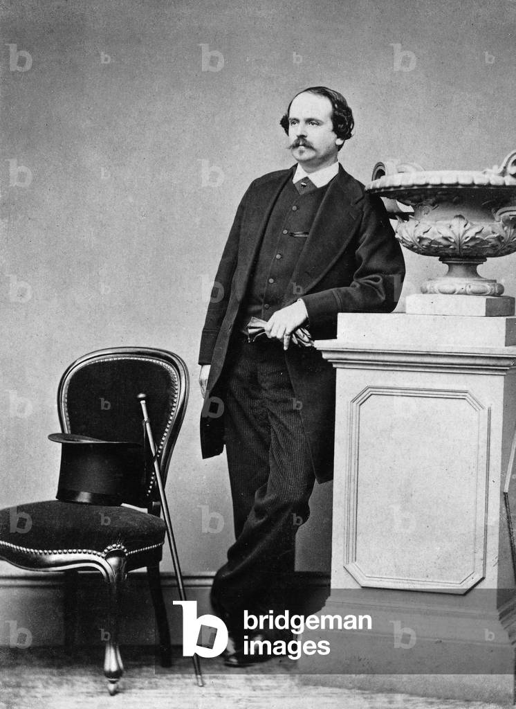 Fashion for men in 1890 : man wearing a frock coat, on a chair are a cane and a top hat