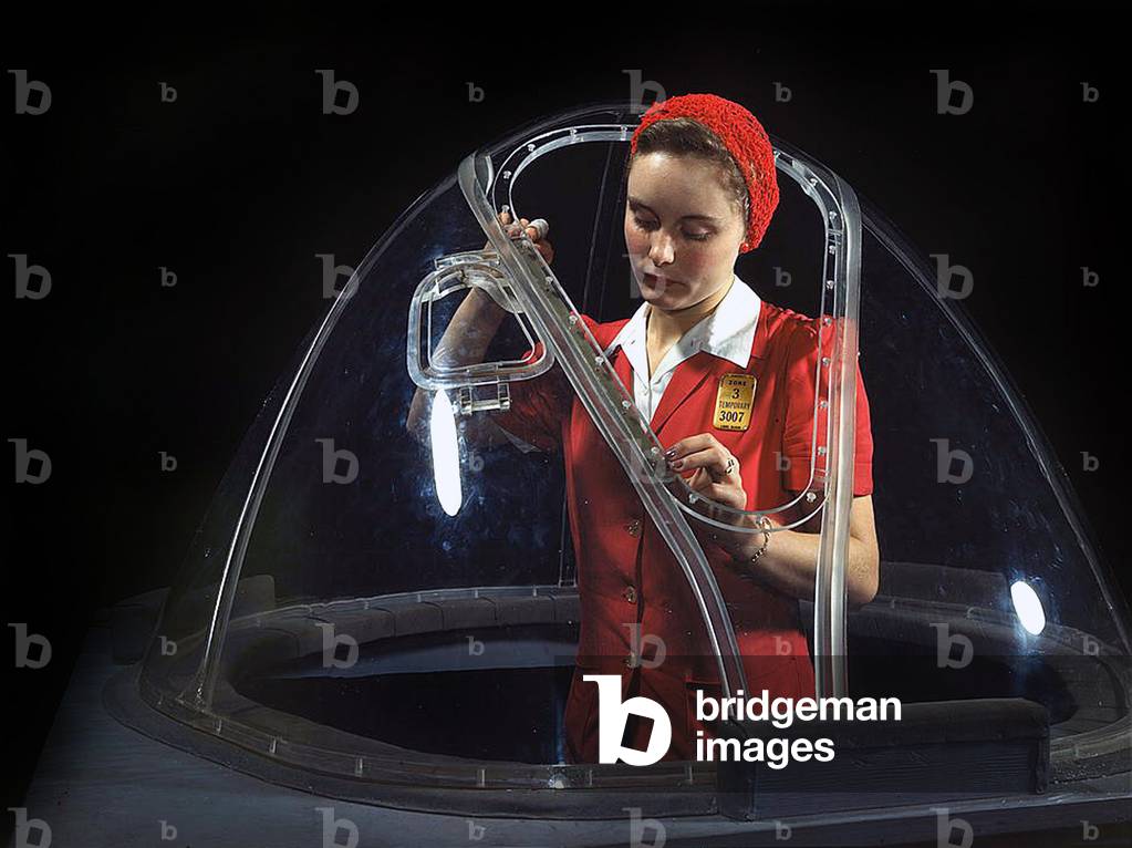 A girl riveting machine operator at the Douglas Aircraft Company plant joins sections of wing ribs to reinforce the inner wing assemblies of B-17F heavy bombers October 1942