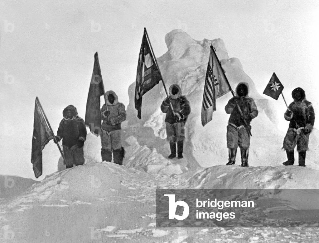 Members of Peary expedition (among them 4 inuit guides) at north pole in 1909 holding flags l-r : Ooqueah with Navy League Flag, Ootah with Delta Kappa Epsilon, Matt Henson with American flag, Egingwah with DAR peace flag and Seegloo with Red Cross