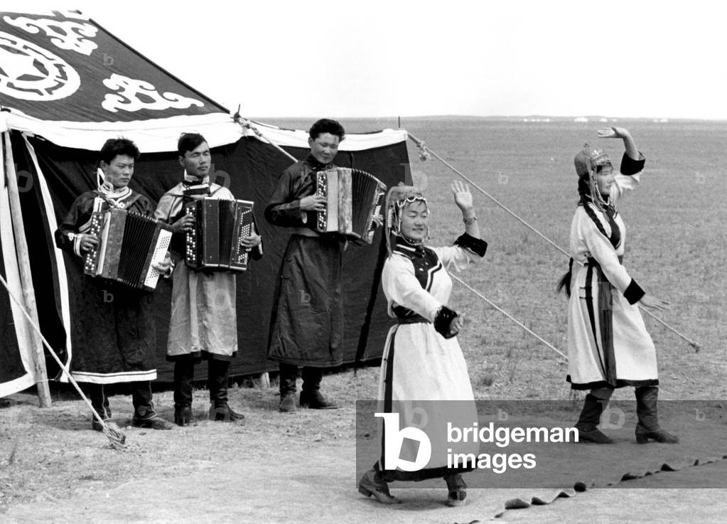 mongolian dancers wearing tradition costumes performing the Tsatsal dance, with three accordionists, South Gobi, Mongolia (they are all sheperds from Tuya farm) December 1964
