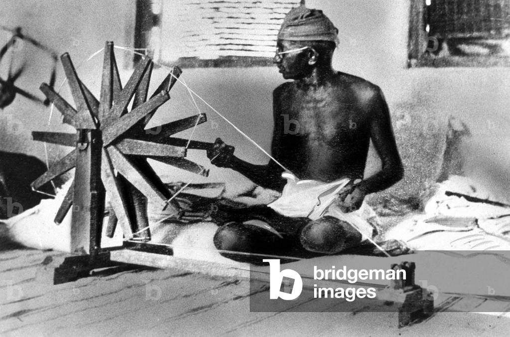 Mahatma Mohandas Karamchand Gandhi (1869-1948) Indian religious man and politician, spinning sitting cross-legged, c. 1925