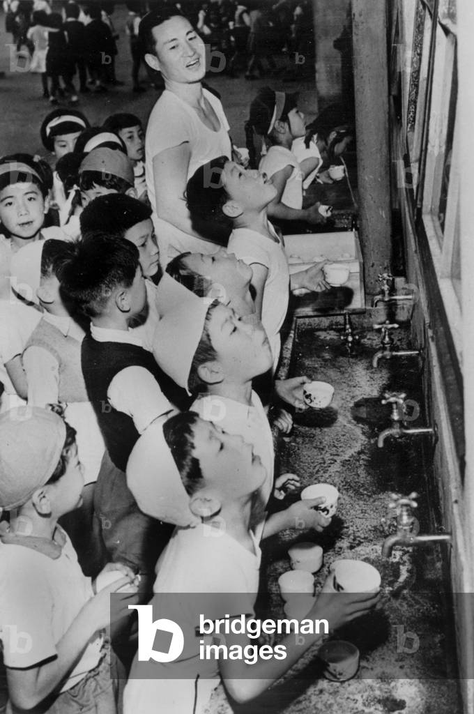 Flu epidemy in Japan : compulsory gargling in the schools in Tokyo June 04, 1957