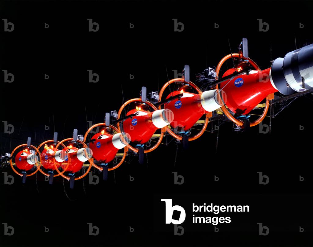 07/02/64 Multiple exposure of Rendezvous Docking Simulator. The Gemini spacecraft was supported in a gimbal system by an overhead crane and gantry arrangement which provided 6 degrees of freedom - roll, pitch, yaw, and translation in any direction - all controllable by the Astronaut in the spacecraft. The controls fed into a computer which in turn provided an input to the servos driving the spacecraft so that it responded to control motions in a manner which accurately simulated the Gemini spacecraft