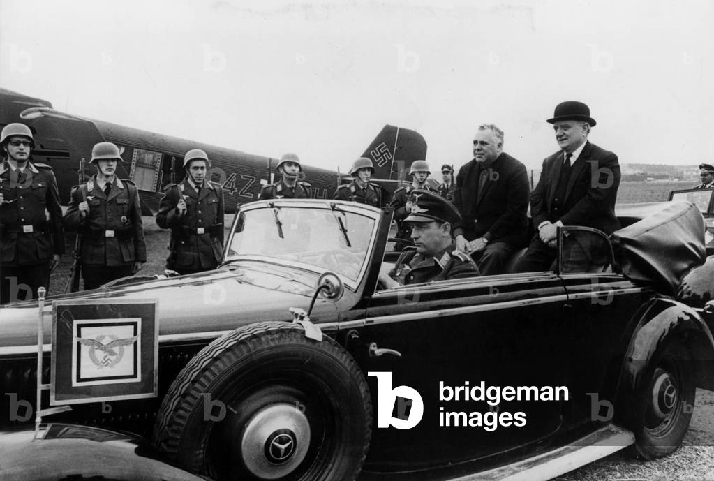 On the shoot of The Battle of England here in a reconstituted German air base in Spain producer Harry Saltzman (left) and his technical advisor Hamish Mahaddie review German troops in a car on 18 March 1968