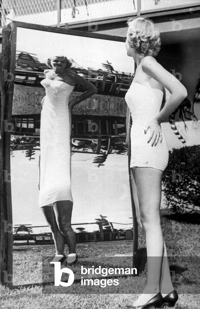 Lorraine Albrecht (18) has won the competition for the most beautiful legs in New York, here looking in a distorting mirror, September 18, 1953