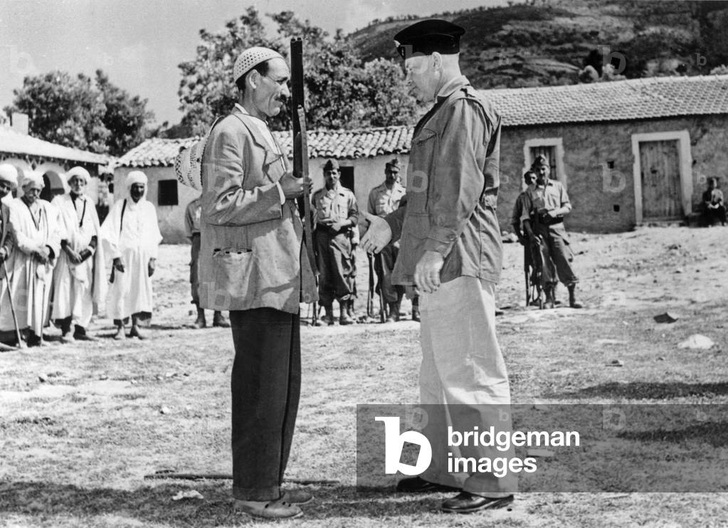 War of Algeria : French Colonel Mareuge giving a riffle to the leader of a Harka, July 1956