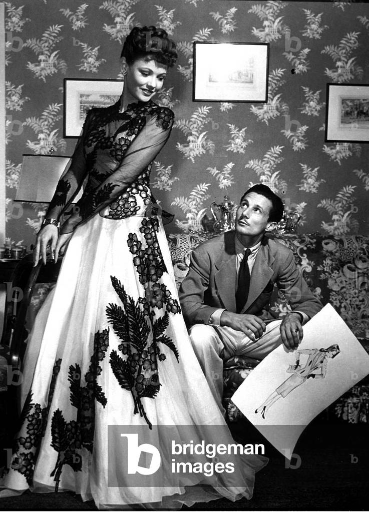 fashion designer Oleg Cassini showing his drawings to Gene Tierney to show her the clothes for film Tobacco Road in 1941