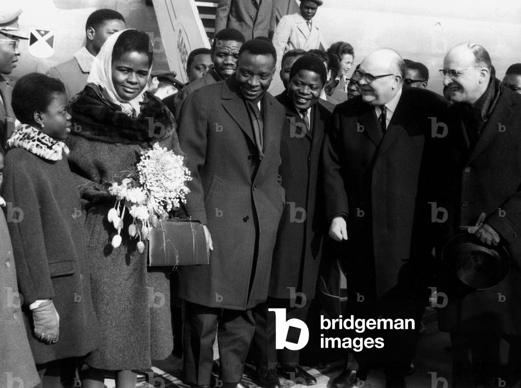 86262PL Mr Cyrille Adoula the Prime Minister of Congo on official visit to Brussels Belgium here has his plane descent with his wife and children to the extreme right Mr Spaak and Mr Lefevre Prime Minister on February 25, 1963