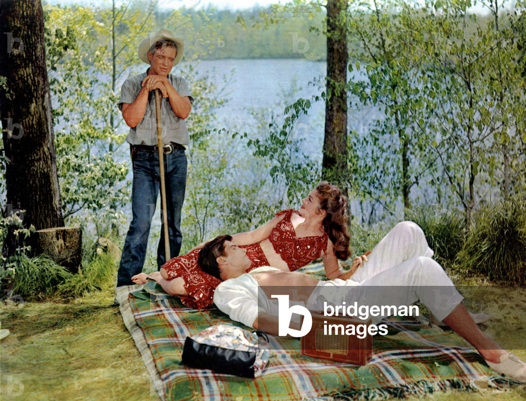 Couple laid on a blanket with a Zenith radio set speaking with a man, c. 1960