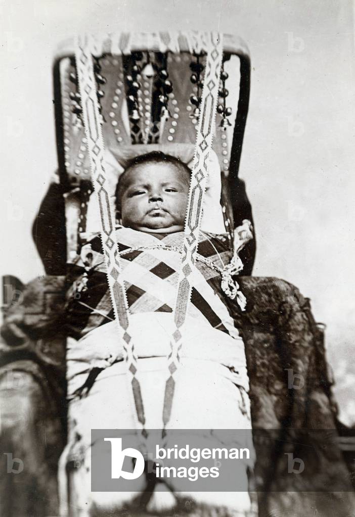 An Osage infant is wrapped in a cradle. This image comes from an Osage album with the inscription: 