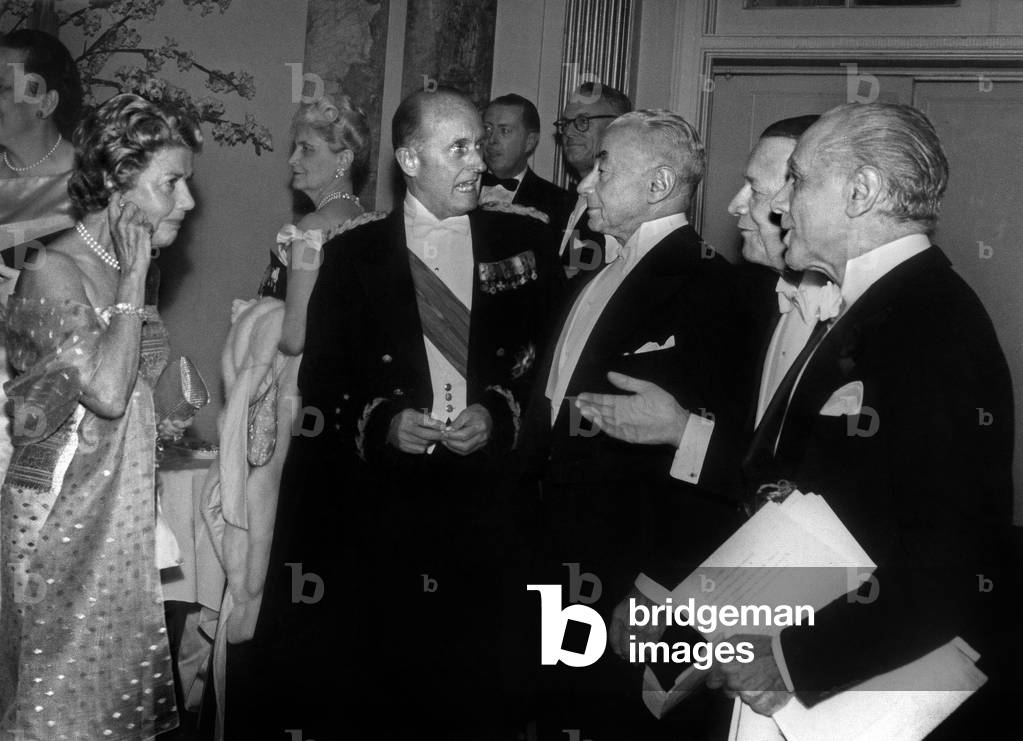Mrs Harvey S. Firestone during a conversation with the President of the American Red Cross General Alfred M. Gruenther the French Prime Minister Paul Reynaud Mr Harvey S. Firestone Jr and Mr Philippe Cortney President of Henri Bendel on 21 April 1961 during a dinner of the French Legion of Honour at the Waldorf-Astoria Hotel in New York