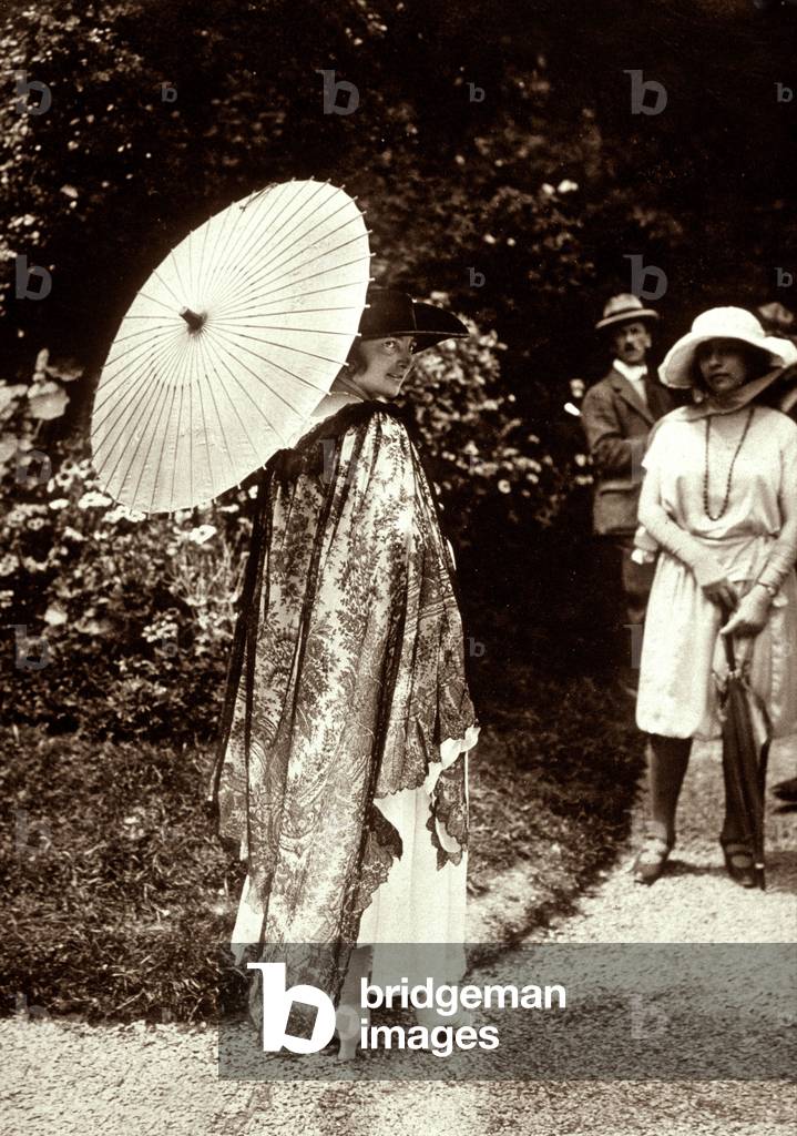 Elegant woman with a japanese sunshade and a cape, 1914