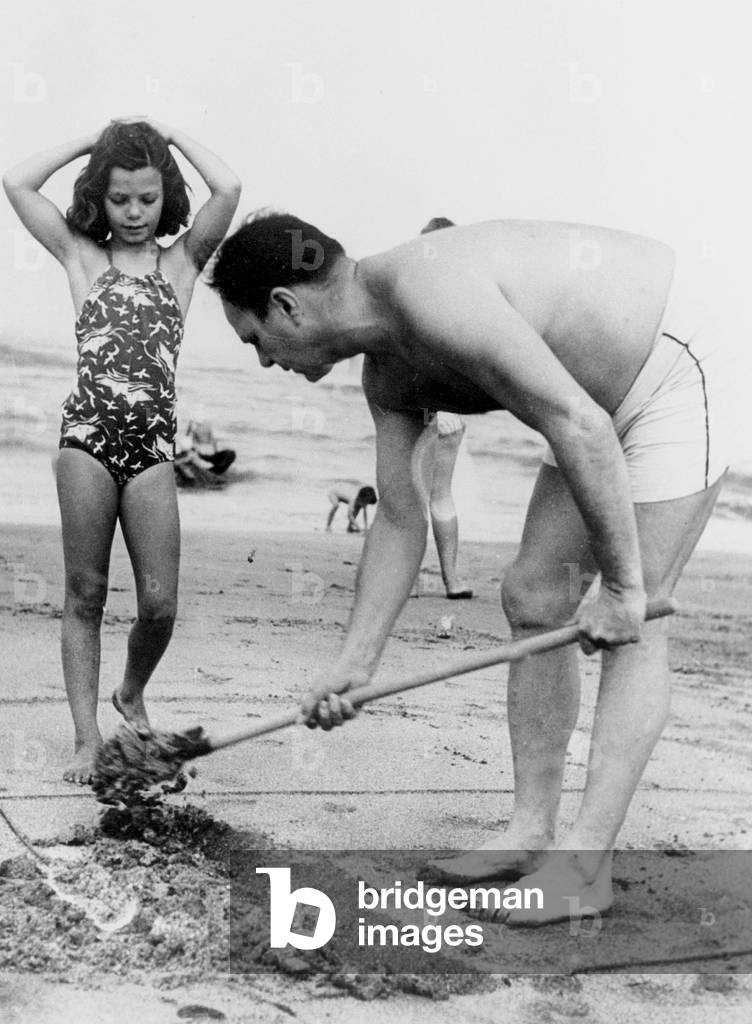 Ali Khan with his daughter Yasmine on the beach in Deauville, France August 29, 1959