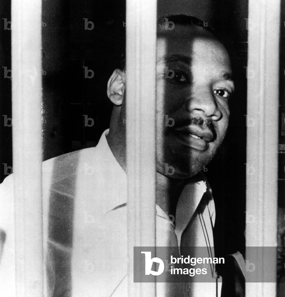 MARTIN LUTHER KING, JR, peers between the bars of his jail cell in the St. John's County Jail, Florida. He was arrested for trespassing, during an integration demonstration, 6/11/62