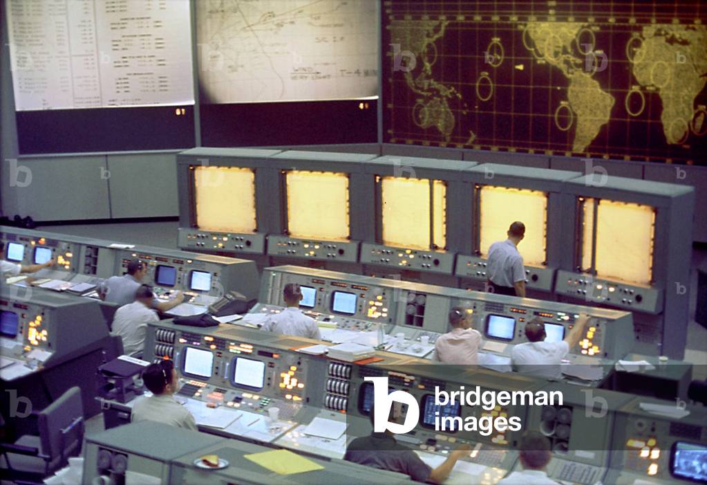 A global view of the Mission Command Centre (MCC) in Houston, Texas, during the flight of the American Space Mission Gemini 5, August 21, 1965. Note the screen on the front of the MCC that is used to track the progress of the Gemini spacecraft