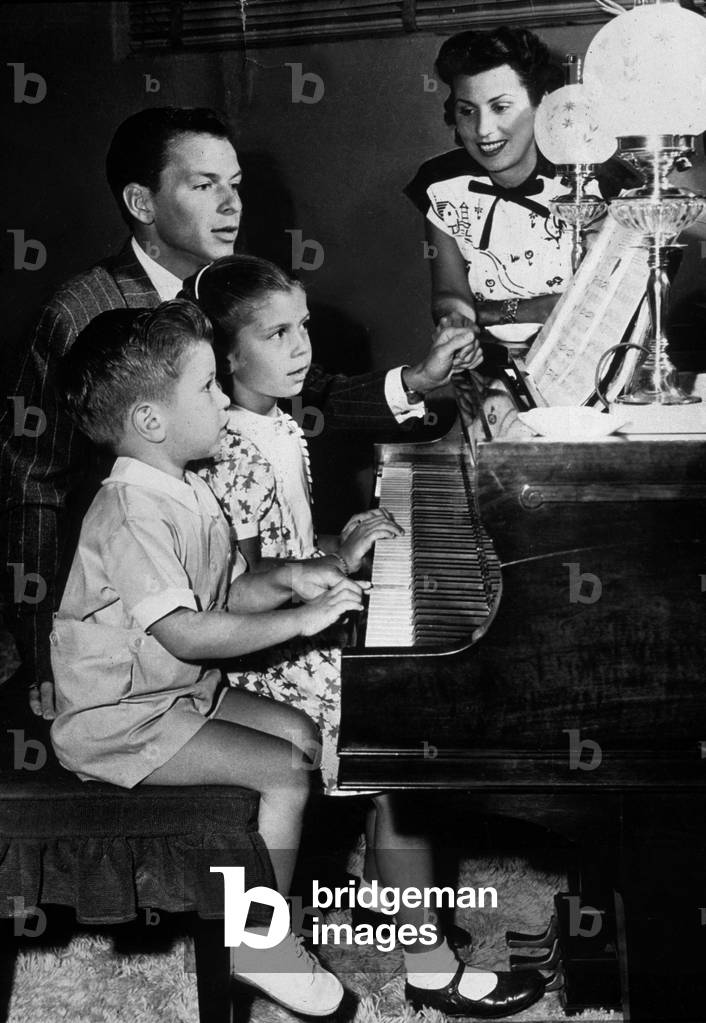 Frank Sinatra with his wife Nancy and their children Nancy and Frank Jr at the piano c. 1948