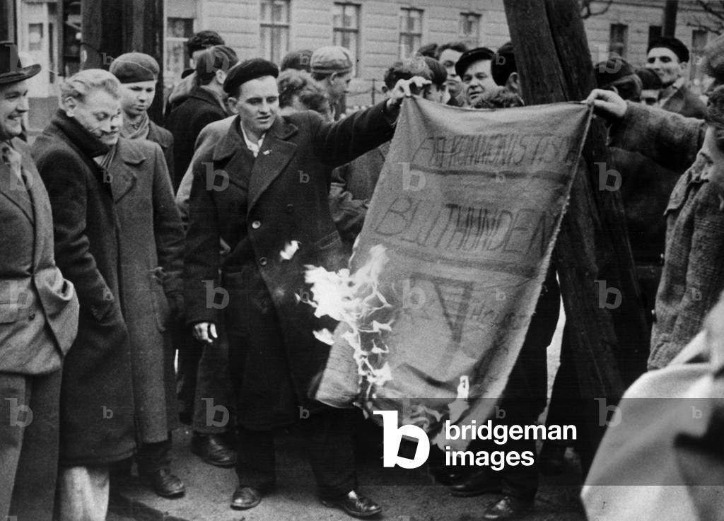 Hungarians refugees, after a demonstyration against the government Kadar, burning effigys of the President in n Austria, February 1957