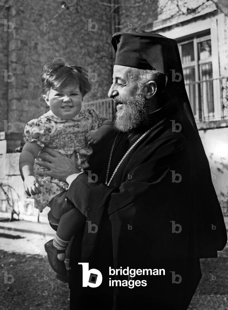 Princess Alexia of Greece, daughter of King  ConstantinII and Queen AnneMarie, in the arms of Cypriot President Makarios III in the gardens of the Royal palace February 07, 1967