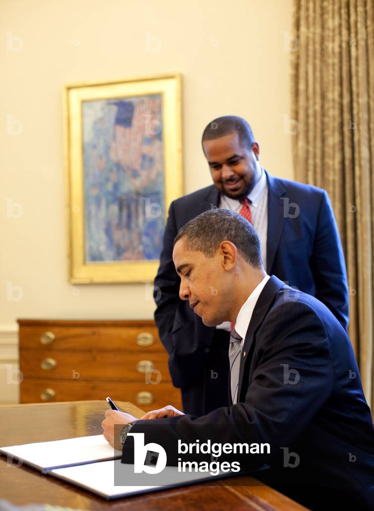 President Barack Obama signs the proclamation marking the National Day of Prayer May 7, 2009. Looking on is Joshua DuBois, Director of the White House Office for Faith-Based and Neighborhood Partnerships