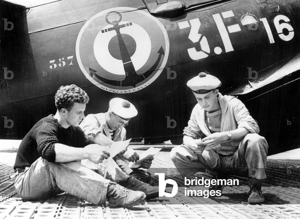 French soldiers reading mail during resting period on Arromanches, 1954 (b/w photo)