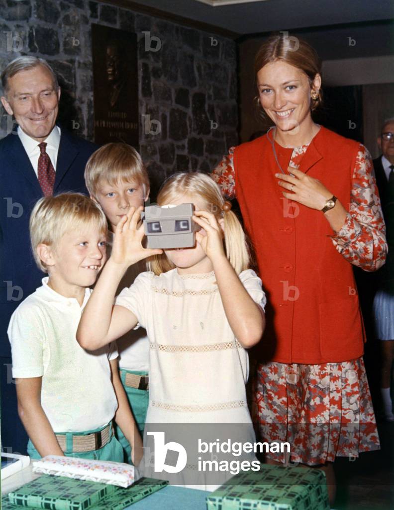 Princess Paola of Belgium and her children Astrid, Philippe and Laurent holding a slides viewer, 1970 (photo)