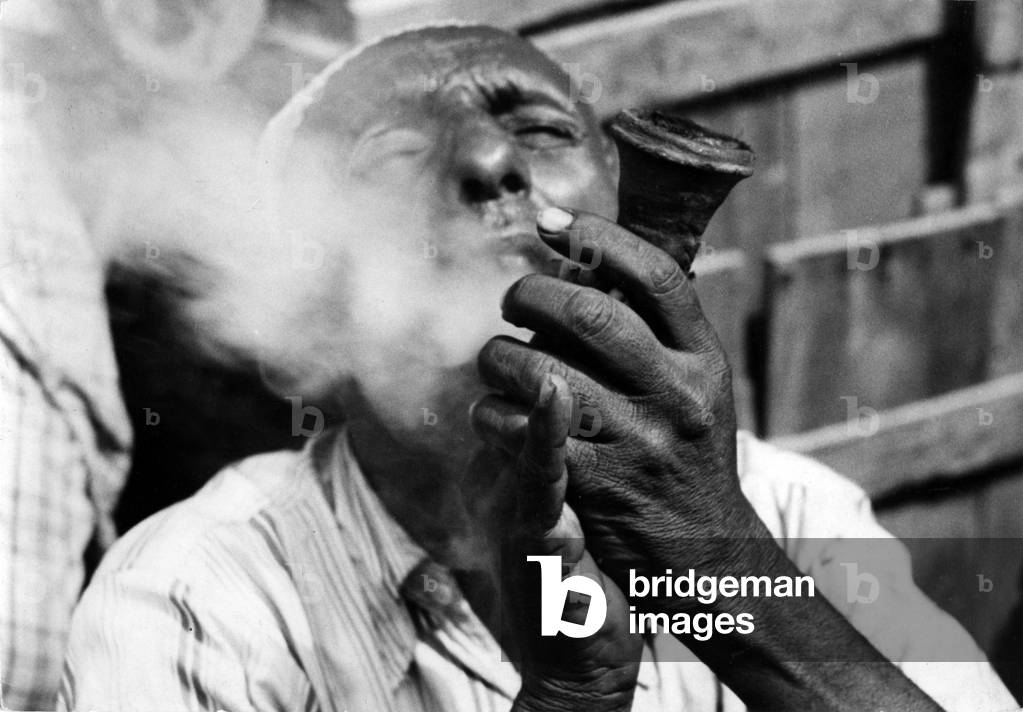 Man smoking from Haschish in Aden, Yemen (b/w photo)