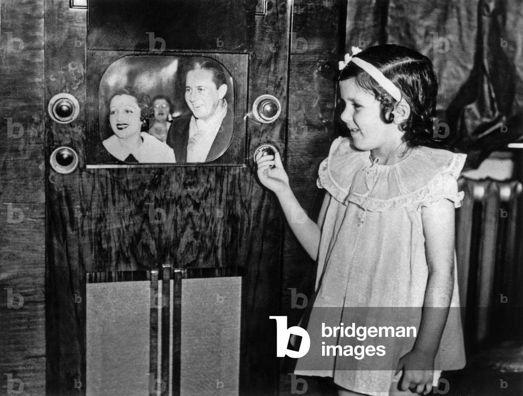 Beginnings of tv set by the late 30s : a young girl watching television